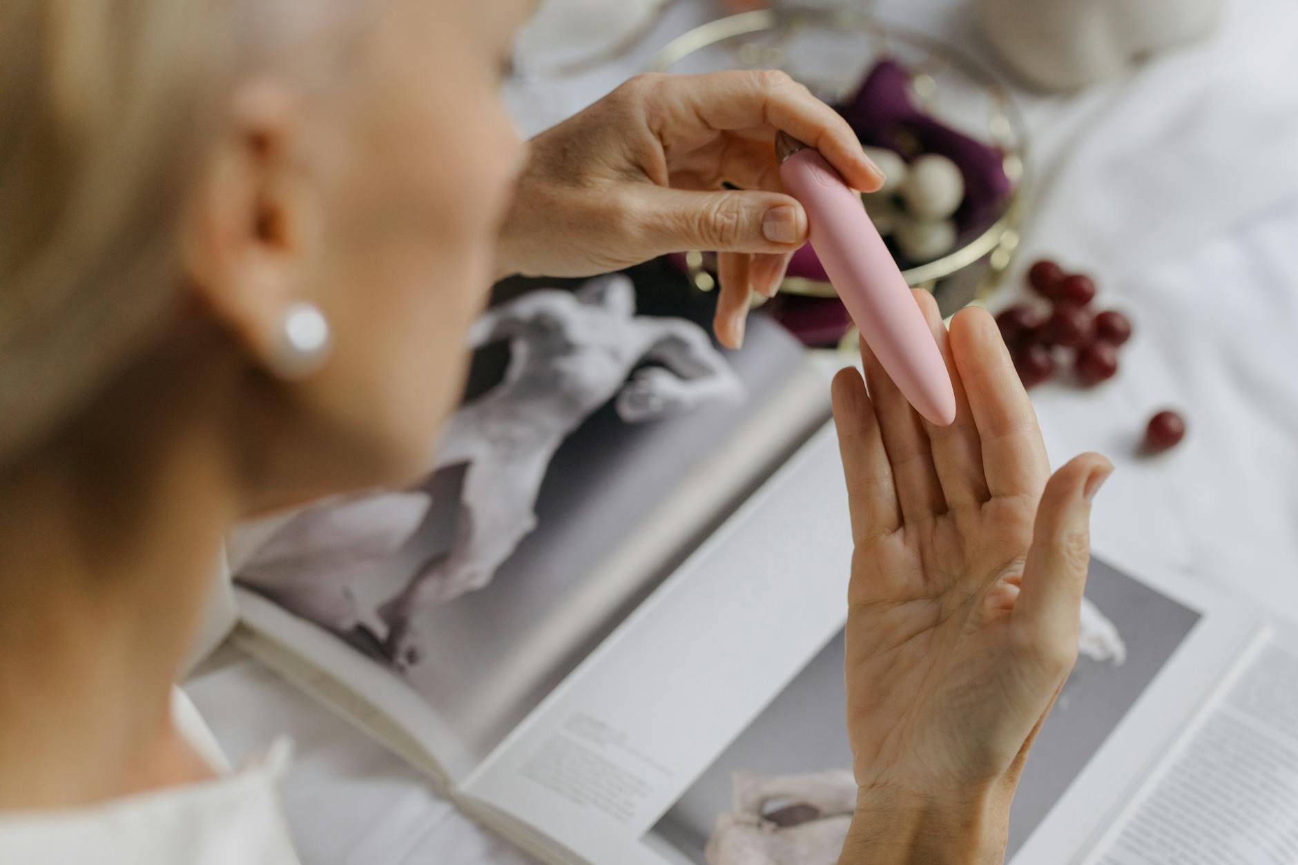 Close-up of a woman holding a vibrator, emphasizing intimate reconnection with pleasure after hormonal changes