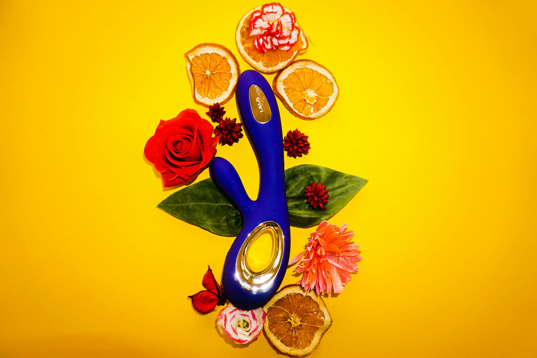 Hand holding an orange vibrator against a minimalistic purple backdrop, symbolizing modern sensuality and healing