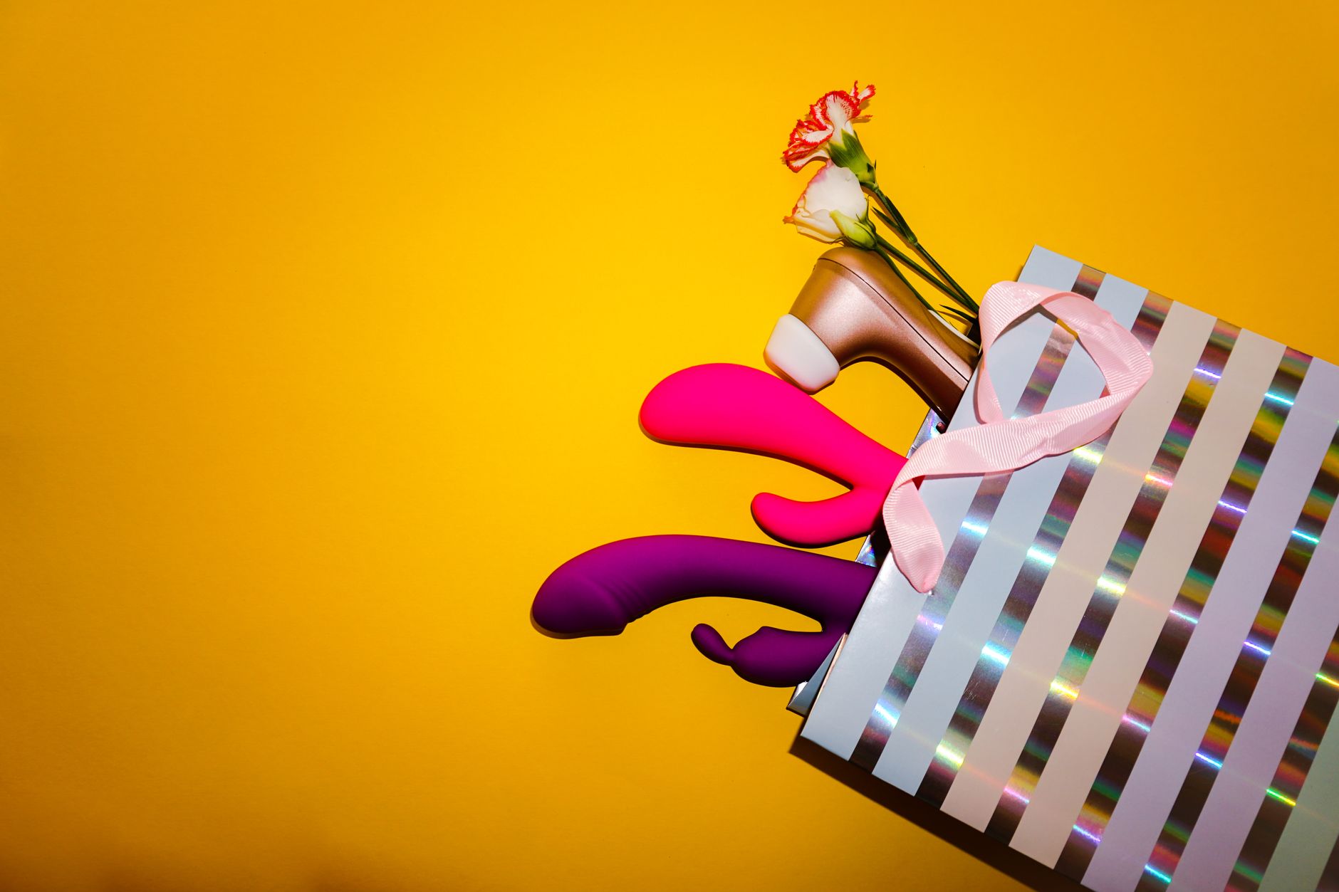 Colorful vibrators arranged on a bright yellow background, symbolizing modern pleasure diversity