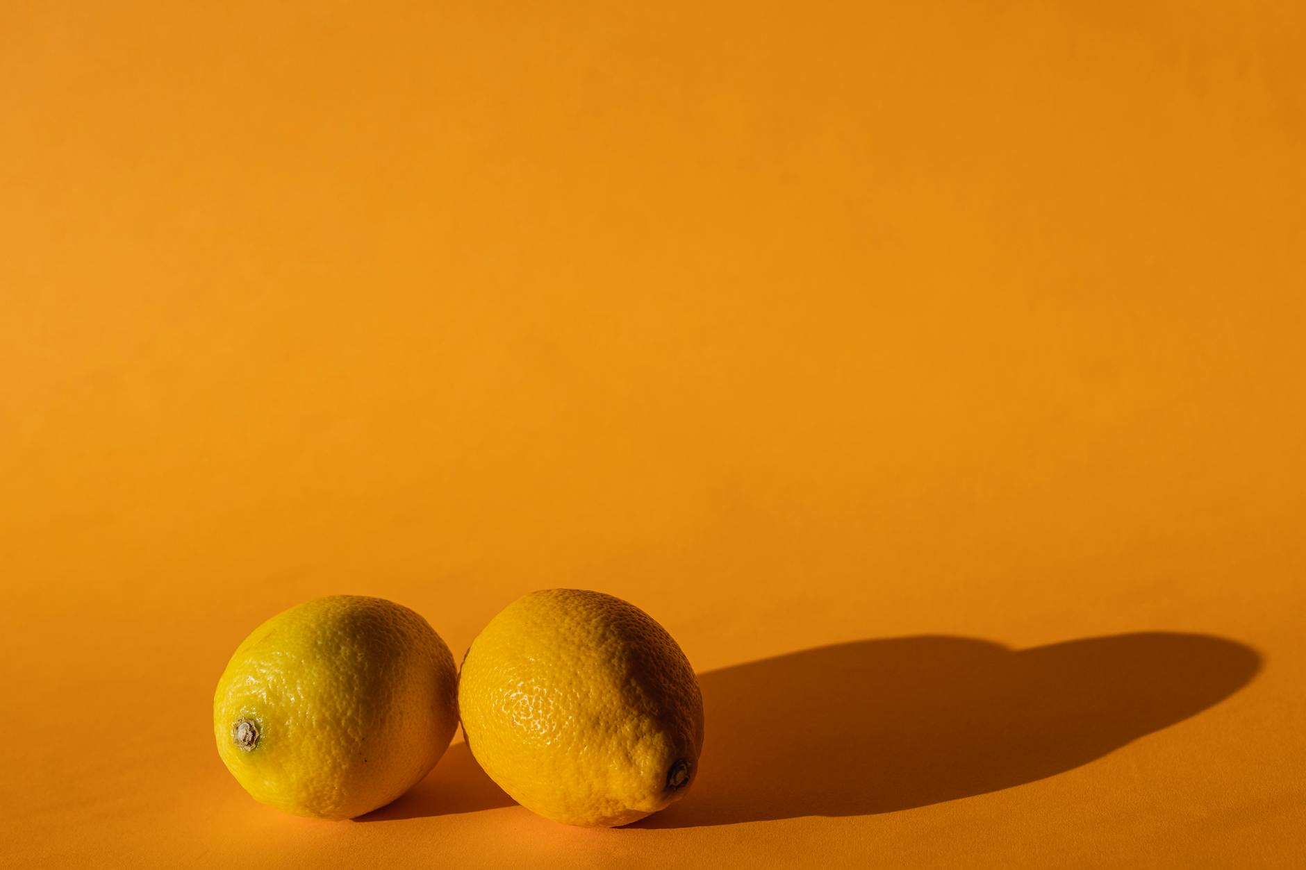 Fresh bright yellow lemons on pastel green background